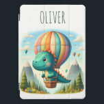 Schattigee Dinosaurus Vliegen in een heteluchtball iPad Pro Cover<br><div class="desc">Laat je kleine ontdekkingsreiziger boven de wolken vliegen met deze gepersonaliseerde iPad-hoes met een charmante dinosaurus op een magisch bergavontuur! Afbeelding een levendige heteluchtballon die over majestueuze pieken drijft, die een grillige scène creëren. Het is ook uniek gepersonaliseerd met de naam van uw kind, waardoor het een gekoesterde aandenken is...</div>