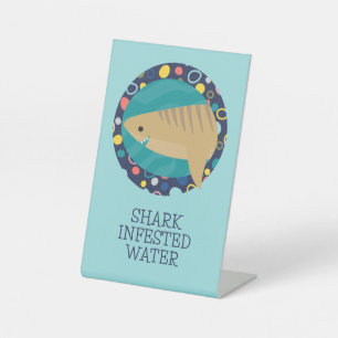 Schattigee haai besmet water reclamebord met voetstuk