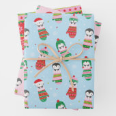 Schattigee kerstpinguïns in gebreide wanten inpakpapier vel (In situ)