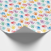 Schattigee veelkleurige geschilderde handen op wit cadeaupapier (Hoek)