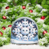 Schattigee witte kattengezichten gerangschikt in e sneeuwbol (Kerstmis)