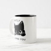 Schattigee zwarte kat oordeelt stilzwijgend over j tweekleurige koffiemok (Voorkant links)