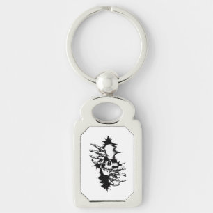 Schedel die door muur heen rijt met skelet handen sleutelhanger