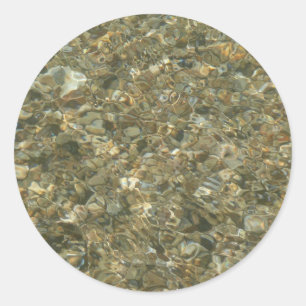 Schelpen onder rimpelend water ronde sticker