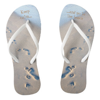 Schilddrukken en voetafdrukken in het zand teenslippers
