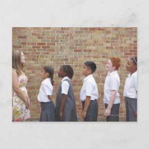 Schoolkinderen staan op de speelplaats voor briefkaart