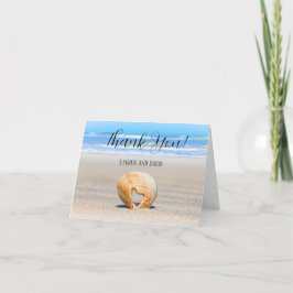 Seashell met een hart op zand bij de strand, bedankkaart