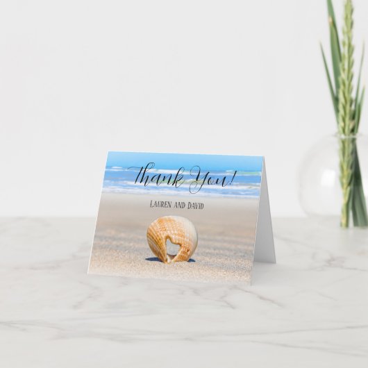 Seashell met een hart op zand bij de strand, bedankkaart (Voorkant)
