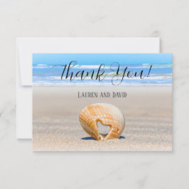 Seashell met een hart op zand bij de strand, bedankkaart