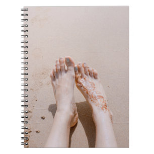 Selectieve focusfoto's van voetjes met tattoo op notitieboek
