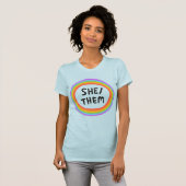 SHE/THEM Pronouns regenboogcirkel kleurig T-shirt (Voorkant volledig)
