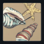 Shell Trio op Khaki Vierkante Klok<br><div class="desc">Megan Meagher staat bekend om haar eenvoudige kunstwerken. Dit is een geweldig afbeelding decoratieve kunst die het leven van het zee vangt met een gele zeester en een blauwe en rode kegelschelp. Profiteer vandaag van deze fijne kunstdruk op de Khaki-kleur op uw Zazzle-product.</div>