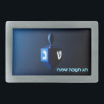 Shiny Blue Dreidel Gesp<br><div class="desc">Een modern, metallic blauw model tegen een donkere, nachtelijke achtergrond. Twee van de Hebreeuwse brieven vonden op een droidel, nun en shin, gloed helder. Hebreeuwse tekst met de tekst "Chag Chanukkah Sameach" (Happy Hanukkah) staat ook in blauw en wit gloeiend.</div>