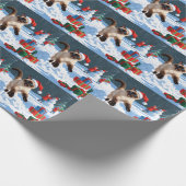 Siamees kat loopt in de sneeuw met kerstmuts cadeaupapier (Hoek)