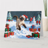 Siamees kat loopt in de sneeuw met kerstmuts kaart (Voorkant)