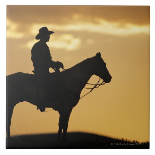 Silhouette van cowboy op horseback bij zonsonderga tegeltje (Voorkant)