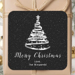 Silver- en Black Ribbon-boom, pretkerst Vierkante Sticker<br><div class="desc">Deze elegante en chique vakantie sticker kan worden gepersonaliseerd met uw familienaam. Het ontwerp is voorzien van een zilveren lint kerstboom met een ster topper. De tekst combineert handgeschreven script en moderne schreefloze lettertypen voor een stijlvolle en verfijnde look. De vallende sneeuw, sneeuwvlokken en schitteringen geven een feestelijke en magische...</div>