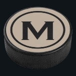 Simple Black Monogram Initiaal Hockey Puck<br><div class="desc">Het minimale monogrammed ontwerp kenmerkt een zwart en beige monogram medallion in een witte klassieke bloktypografie. Pas uw initiaal aan.</div>