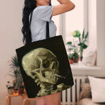 Skelet met brandende sigaret | Vincent van Gogh Tote Bag<br><div class="desc">Skull of a Skeleton with Burning Cigarette (1886) van Vincent van Gogh is een opvallend en onconventioneel stillevenschilderij met een menselijke schedel met een aangestoken sigaret tussen de tanden. De donkere achtergrond versterkt de helderheid van het skelet, terwijl de kleine rookpluim een gevoel van vergankelijkheid en ironie toevoegt. Dit kunstwerk,...</div>