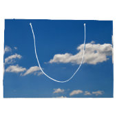 Sky is blauw en witte wolken gaan langs groot cadeauzakje (Achterkant)