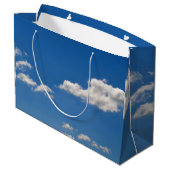 Sky is blauw en witte wolken gaan langs groot cadeauzakje (Achterkant Gekanteld)