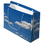 Sky is blauw en witte wolken gaan langs groot cadeauzakje (Voorkant Gekanteld)