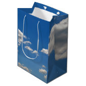 Sky is blauw en witte wolken gaan langs medium cadeauzakje (Voorkant Gekanteld)