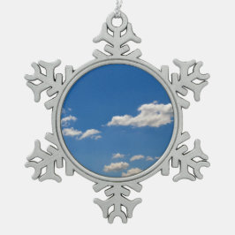 Sky is blauw en witte wolken gaan langs tin sneeuwvlok ornament