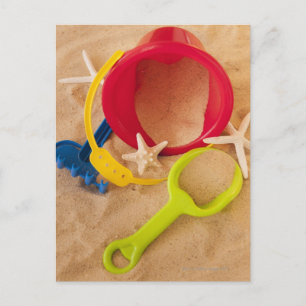 Sluit omhoog van speelgoed op zand briefkaart