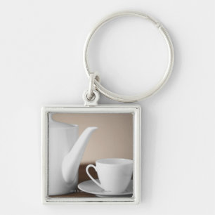 Sluiten van een beker en een saucer met een theeke sleutelhanger