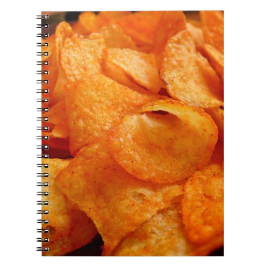 Sluiten van sappige, knapperige chips op zwart bor notitieboek (Voorkant)