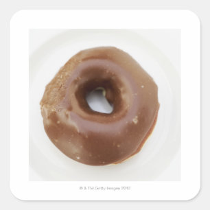 Sluiting van een chocoladedoughnut op een bord vierkante sticker