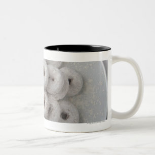 Sluiting van poederdonuts in een bord tweekleurige koffiemok