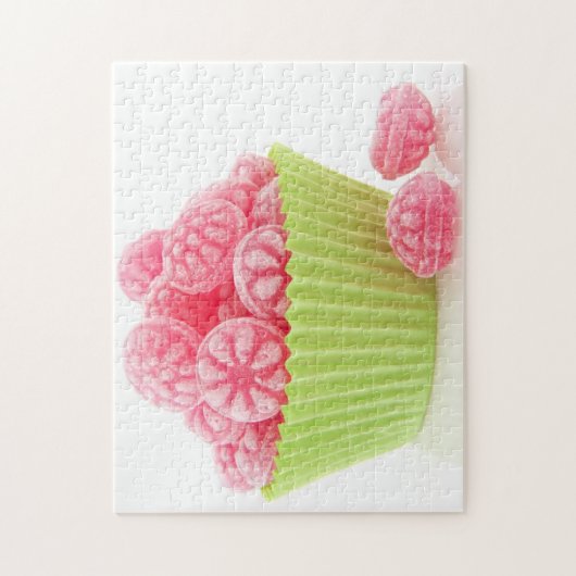 Smaak van frambozenachtige snoepjes in groene beke legpuzzel (Verticaal)