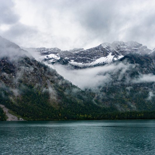 Sneeuwberggebieden in de mist bij het Plansee-meer Douchegordijn