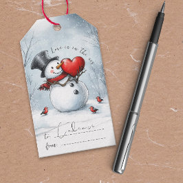 Sneeuwman biedt liefde met een cadeautag met een g cadeaulabel