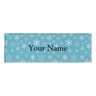 Sneeuwvlokken op blauwe achtergrond naambadge