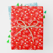 Sneeuwvlokken op blauwe en rode, groene kerstbomen inpakpapier vel (In situ)