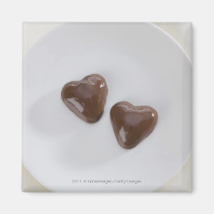 Snoepjes van harsvormige chocolade op een bord magneet