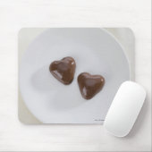 Snoepjes van harsvormige chocolade op een bord muismat (Met muis)