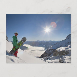 Snowboarder kijkt van bergtop briefkaart