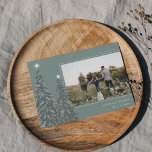 Snowy Pines | Kerstfoto van Elegant Feestdagenkaart<br><div class="desc">Een modern en elegant kerstfeestkaartje met een horizontale foto op een groene achtergrond voorzien van pijnbomen die zijn voorzien van sneeuw en voorzien zijn van witte sterren. Pas uw eigen vakantiegroet,  uw familienaam en het jaar aan.</div>