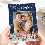 Snowy Winter Village Merry Kerst2 Foto Feestdagenkaart<br><div class="desc">Verstuur de feestdagen naar familie en vrienden met een Snowy Winter Village-kerstfotokaart van Late Bloom Paperie! De feestelijke kerstkaart toont "Zware Kerstmis"bij de bovenkant in een gewaagd wit manuscript. De onderkant van de kaart is voorzien van een sneeuwwinterstad met kerstverlichting, vakantieworsten, kerstbomen en een sneeuwman! Sneeuwvlokken grenzen de kaart in...</div>