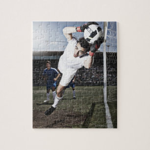Soccer goalie vangt voetbal legpuzzel