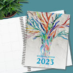 Speciaal voor 2023 ontworpen boom of life planner<br><div class="desc">Deze unieke Planner is versierd met een helder gekleurde Levensboom op een bleke grijze achtergrond. Het oorspronkelijke ontwerp werd gemaakt in mozaïek met kleine stukjes helder glas. Pas het aan met jouw naam en jaar. Om verder uit te geven gebruik het Hulpmiddel van het Ontwerp om de doopvont, de doopvontgrootte,...</div>