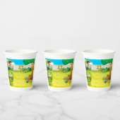 Speelse jongen die in een weelderige groene achter papieren bekers