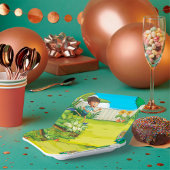 Speelse jongen die in een weelderige groene achter papieren bordje