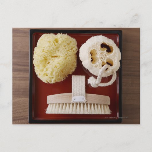 Sponge, loofah, penseel op het rode bakje briefkaart (Voorkant)
