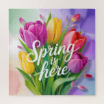 "Spring is Here" Tulip Bouquet Illustration Legpuzzel<br><div class="desc">A vibrant and cheerful digital illustration featuring a lush bouquet of tulips in shades of purple, yellow, and coral pink. The bouquet is overlaid with elegant, white cursive typography that reads "Spring is here". The background consists of soft, painterly watercolor washes in pastel green, purple, and peach.</div>