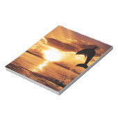 springdolfijn met prachtige zonsondergang over het notitieblok (Linkerzijde)